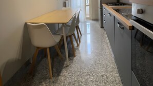 Eine moderne Küche mit Essbereich, Granit-Arbeitsplatten und einer Wanduhr.