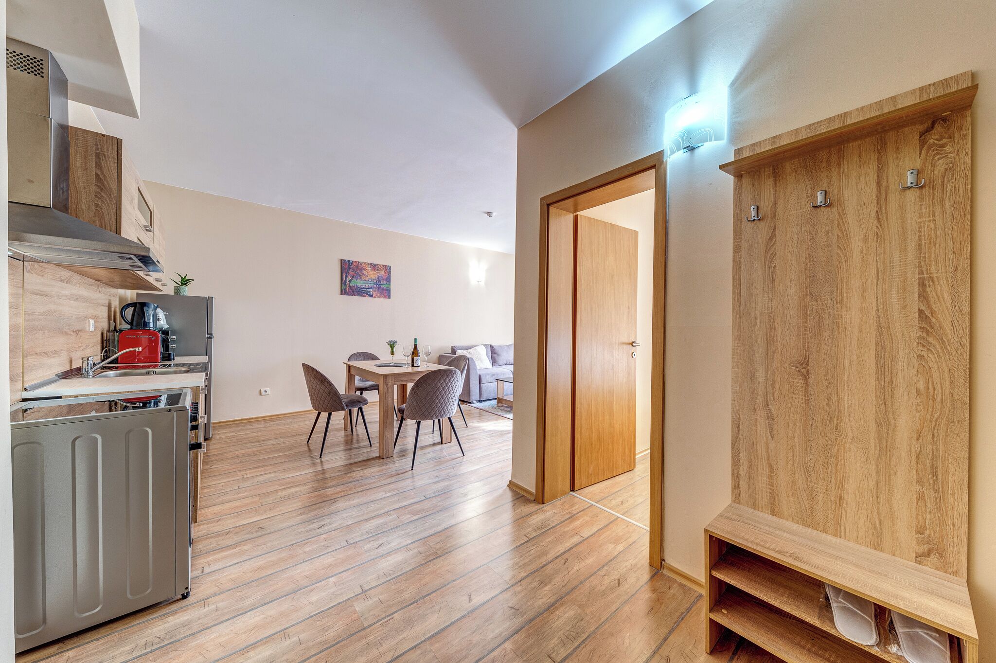 Una cocina moderna con estufa integrada, un comedor con mesa y sillas, y un armario de madera.