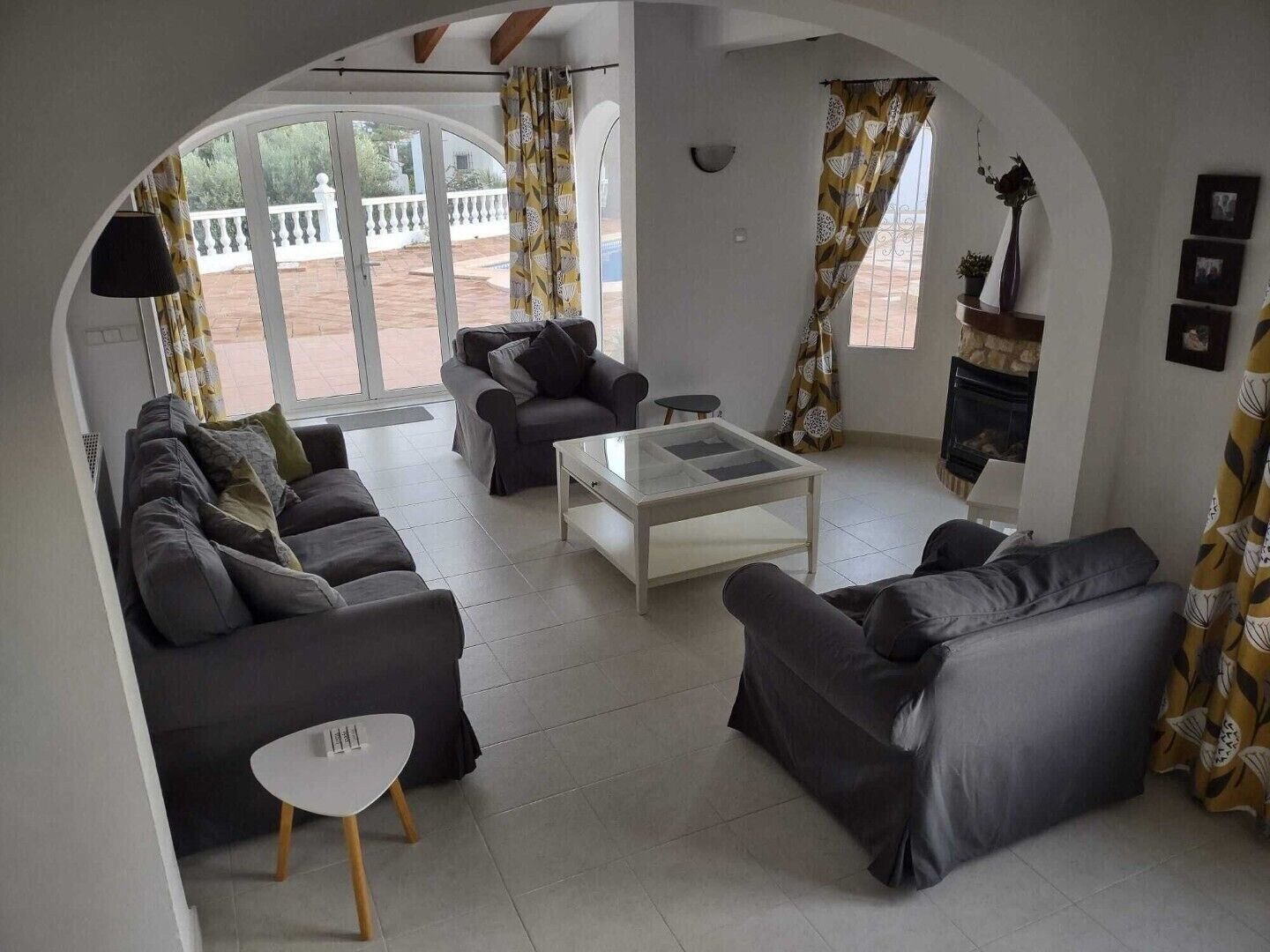 A living room with a sofa set, a coffee table, and curtains.