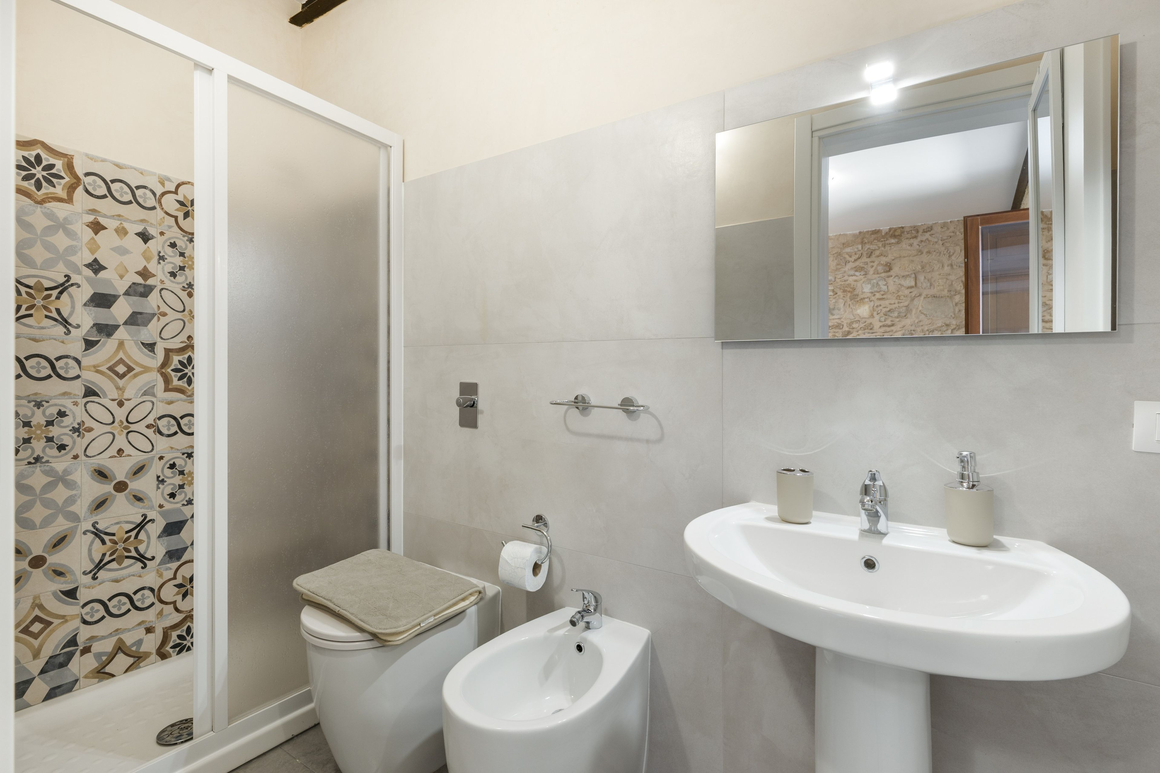 A bathroom with a toilet, bidet, and sink.