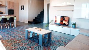 A modern living room with a TV, sofa, coffee table, and patterned floor.