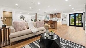 Un salon moderne avec un canapé, une table basse et une vue sur la cuisine.