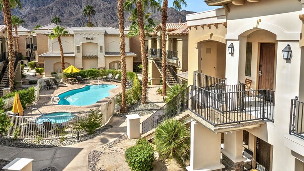 Ein Resort mit Pool, Palmen und Bergblick.