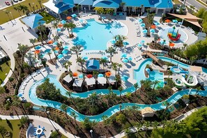 Ett flygbildsbild av ett semesterområde med flera pooler, vattenrutschkanor och avkopplingsområden.