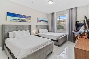 Habitació d'hotel amb dos llits, un finestral gran i obres d'art a les parets.