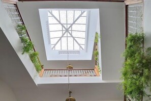A skylight with a cross pattern, a wooden floor, and green plants. - Riad with Swimming Pools (Marrakech)