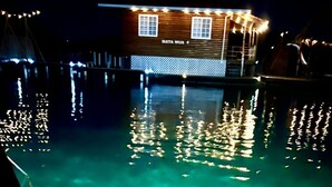 A clear pool with reflections of lights and a wooden building in the background. - Isla privada Mata Mua (Bocas del Toro)