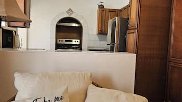 A kitchen with wooden cabinets, a built-in oven, and a ceiling fan.