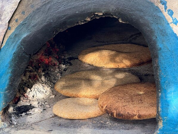 A stone oven with bread baking inside. - Dar diafa Jennane (Zoumi)
