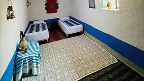 A room with two beds, a patterned rug, a lantern, and a window with a view. - Dar diafa Jennane (Zoumi)