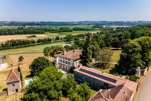 Una propiedad rural con una casa grande, una edificación más pequeña y una piscina.