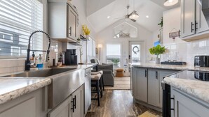 Una cucina moderna con isola centrale, elettrodomestici in acciaio inossidabile e ventilatore a soffitto.