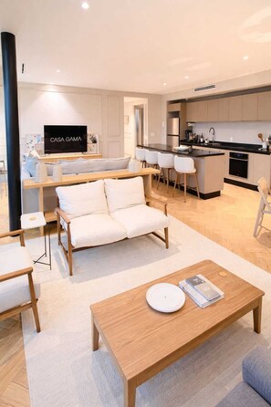 A modern living room with a sofa, coffee table, and a TV displaying 'CASA GAMA'. - Casa Gama Colibri (Ciudad de México)