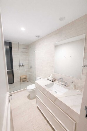 A modern bathroom with a glass shower enclosure, a large mirror, and a dual sink vanity. - Casa Gama Colibri (Ciudad de México)