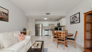A modern apartment with a living room, dining area, and kitchen.