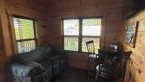 Ein gemütliches Blockhaus-Interieur mit Sofa, Esstisch und Stühlen.