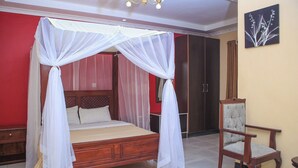 A bedroom with a four-poster bed, a wooden chair, and a wardrobe. - Hoyjiifka Holale Resort (Moyale)
