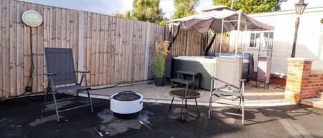 Ein Garten mit Grill, Gartenmöbeln und einem Holzzaun.