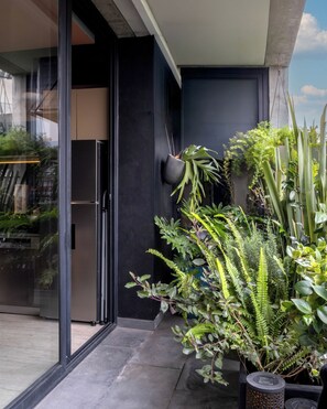 A modern building with a glass door entrance, a black wall, and a variety of indoor plants. - Casa Gama Gabriel | Art & Design in Northern Rome (Ciudad de México)