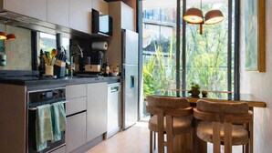 A modern kitchen with a dining area, large windows, and a view of greenery. - Casa Gama Gabriel | Art and Design in Northern Rome (Ciudad de México)