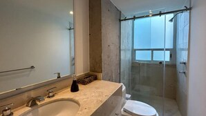 Ein modernes Badezimmer mit großem Spiegel, einer Badewanne, einer Toilette und einer Duschkabine.