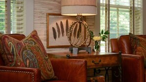 A room with a wooden desk, a lamp, and two leather sofas with patterned cushions. - Deer Brook Inn  (Woodstock)