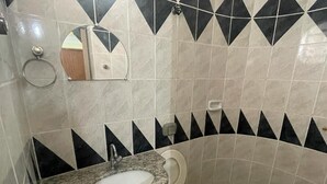 Un baño con lavamanos, inodoro y espejo.