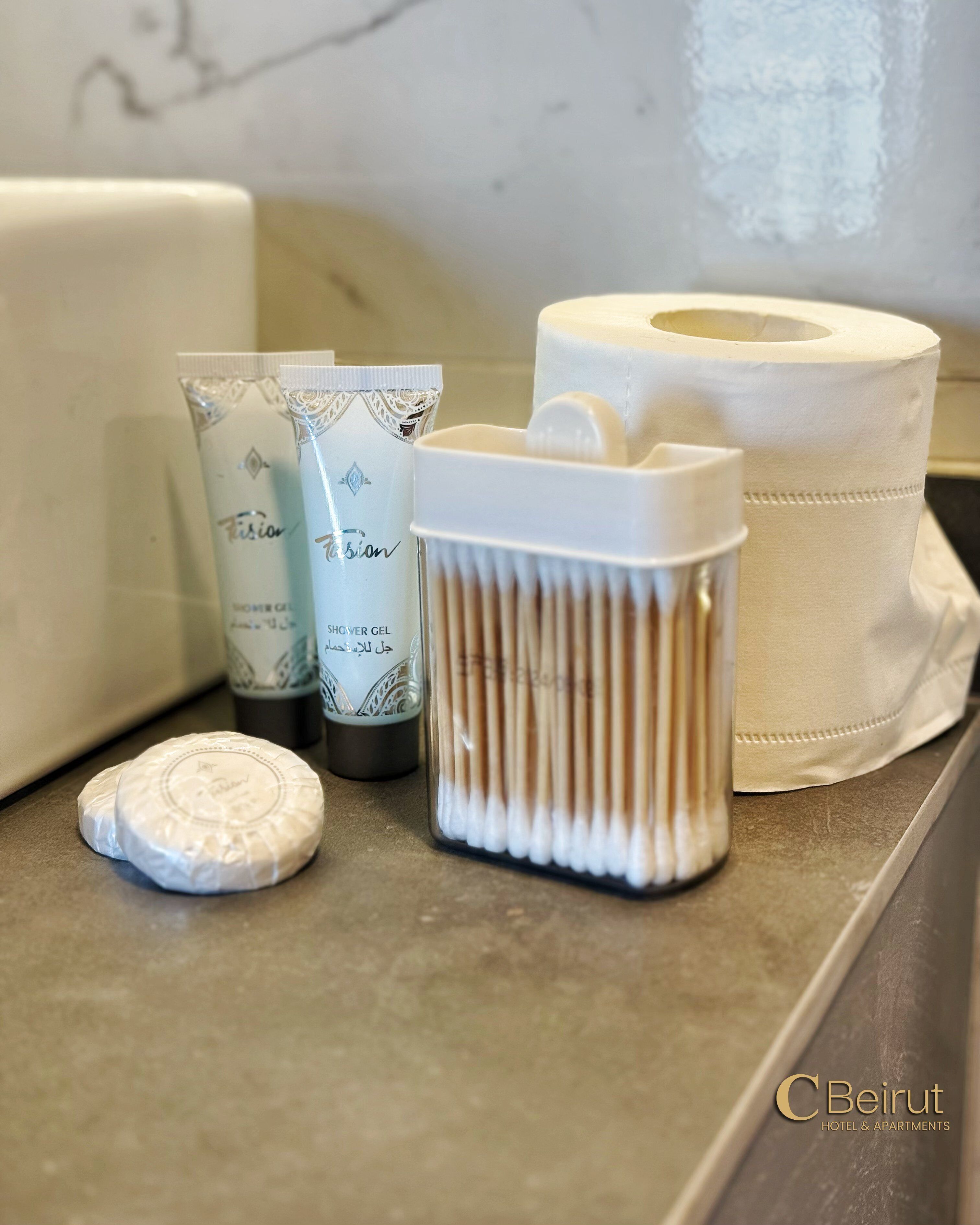 Toiletartikelen op een badkamermeubel, waaronder een tandenborstelhouder, een zeepstaaf en twee tubes douchegel.
