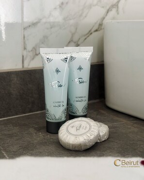 Two shower gel bottles and a bar of soap on a bathroom countertop. - C Beirut Hotel & Appartment (Mar Roukouz)