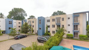 A residential building with multiple floors, balconies, and a parking area. - Libi Apartment-BlueWaters Property  (Accra)