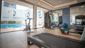A gym with a treadmill, exercise bike, and weights. - Libi Apartment-BlueWaters Property  (Accra)