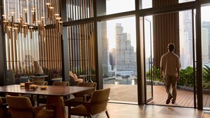 A modern interior with a dining area, large windows, and a view of the cityscape. - Andaz One Bangkok, by Hyatt (Bangkok)