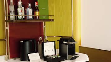 A minibar with various liquor bottles, a coffee machine, and a coffee selection sign.