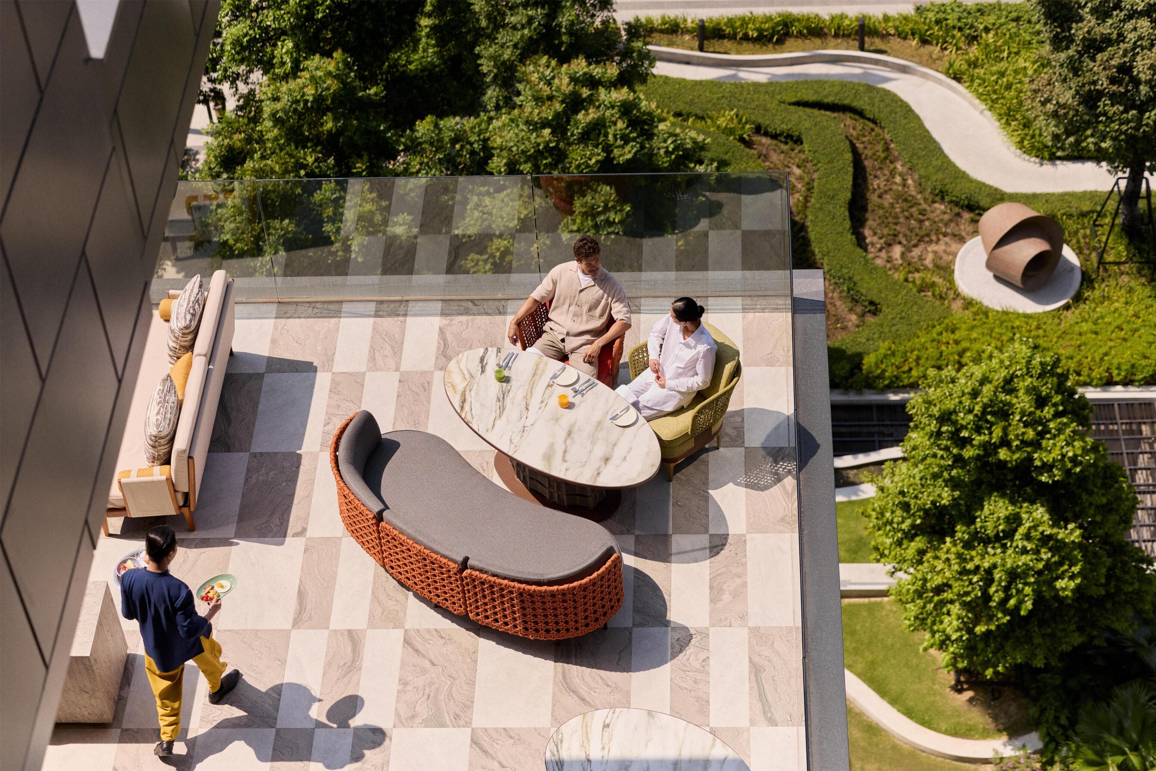 A rooftop terrace with a checkered floor, outdoor seating, and a landscaped garden.