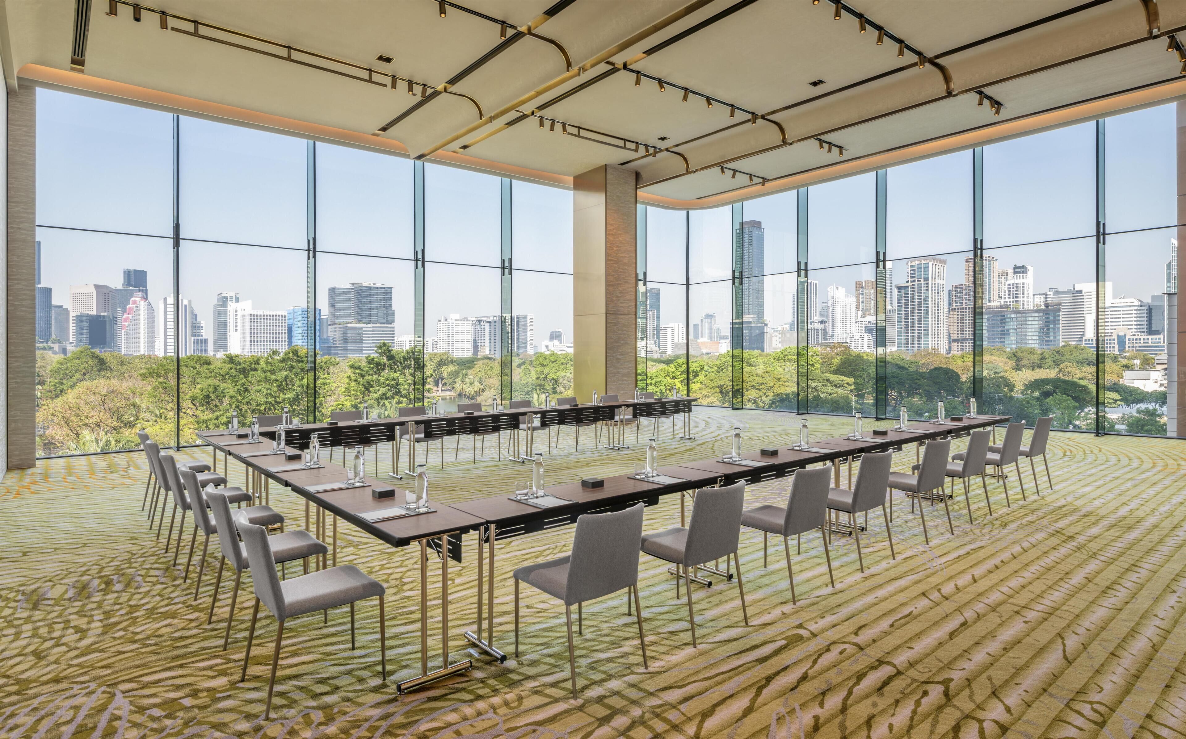 A conference room with a city view, large windows, and a patterned carpet.