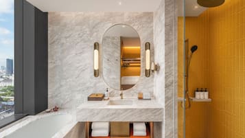 A modern bathroom with a large mirror, a bathtub, and a shower.