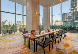 A conference room with a long table, chairs, and a city view through large windows. - Andaz One Bangkok, by Hyatt (Bangkok)