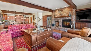 Una sala de estar amplia con chimenea, comedor y cocina.