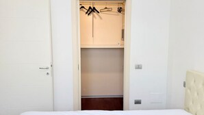 Een slaapkamer met een bed, een kledingkast met spiegel en een deur.