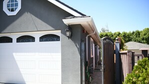 A residential garage with a white door, a small window, and a light fixture on the wall. - Private In-Law Suite with Kitchenette in Sunnyvale next to Park (Sunnyvale)