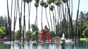 A park with a water fountain, palm trees, and a playground with a red slide. - Private In-Law Suite with Kitchenette in Sunnyvale next to Park (Sunnyvale)