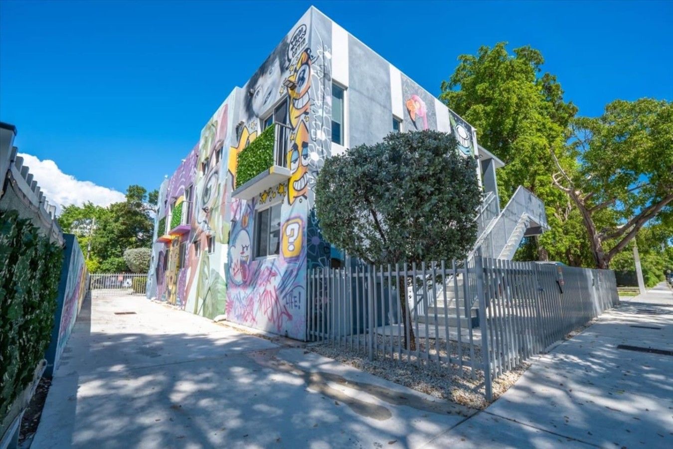 Un bâtiment dont les murs extérieurs sont décorés de graffitis colorés.