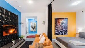 A modern living room with a sofa, a TV, and artwork on the walls. - Prime Location Free Parking By Nightlife & Eats (Miami)