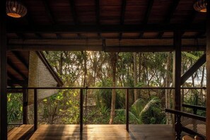 A wooden deck with a view of dense tropical foliage. - Sama Retreats (Galle)