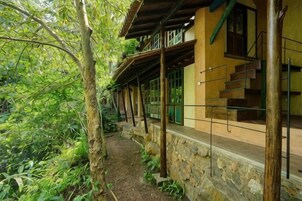 Un edificio con base de piedra, vigas de madera y un corredor cubierto.
