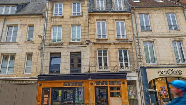 A row of historic buildings with a boutique store named 'octobre' on the right.