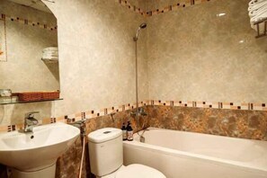 Une salle de bain avec un lavabo, des toilettes et une baignoire.
