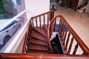 Eine Holztreppe mit Handlauf, die zu einer höheren Etage führt.