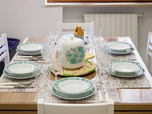 A dining table set with plates, glasses, and cutlery. - Nennè Home: Spacious and Cozy Comfort in the Heart of Sorrento (Sorrento)