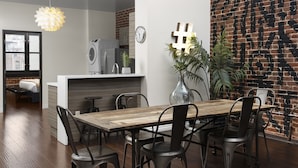 Una cocina moderna con encimera de madera, lavadora integrada y pared de ladrillo con un letrero decorativo de numeral número.